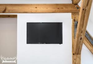 TV en la pared con marco de madera en Pokoje hotelowe Nad jeziorem Jelen, en Bytów