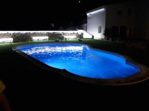 a large blue swimming pool at night at Villa Verde in Alcamo