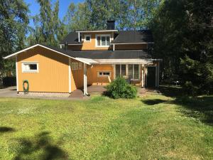 a small yellow house with a lawn in front of it at Villa Toivo in Rovaniemi