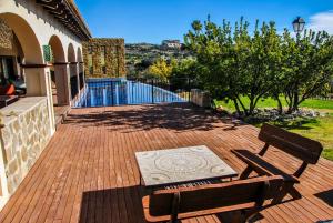 una terraza de madera con 2 sillas y una mesa en Mirador del Torcal, en Antequera