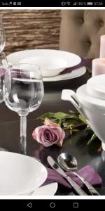 a table with white plates and a glass of wine at Modernes 3-Zimmer-Apartment nahe Graz in Gratkorn