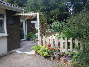 una recinzione di legno di fronte a una casa con fiori di Grove lodge a Aglish