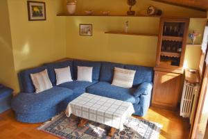 a blue couch in a living room with a table at Appartamento Gorgotto in Gravedona