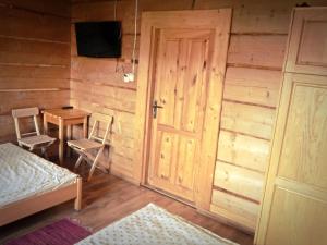 a room with a bed and a table and a door at Pokoje u Kalaty in Szaflary