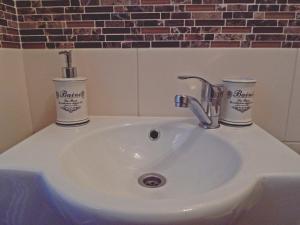 a bathroom sink with two cups on top of it at Pokoje u Kalaty in Szaflary +24 photos