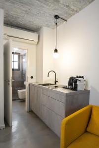 a kitchen with a sink and a yellow couch at Square Rooms 8 in Düsseldorf