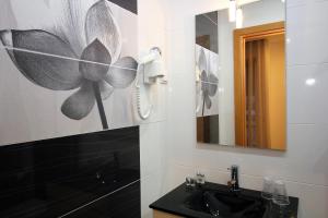 a bathroom with a sink and a mirror at Gaivota Holidays in Nazaré