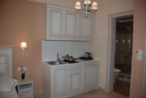 a white kitchen with a sink and a toilet at Elxis Luxury Resort in Nea Vrasna +90 photos