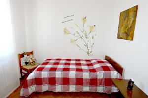 ein Schlafzimmer mit einem roten und weißen karierten Bett in der Unterkunft Annabelle in Somma Lombardo