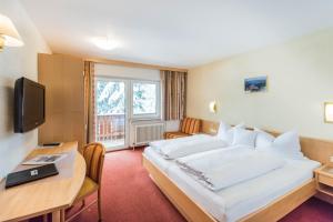 Pokój hotelowy z dużym łóżkiem i biurkiem w obiekcie Hotel Garni Waldhof - Wohlfühlen am Lech w mieście Stanzach