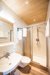 a bathroom with a sink and a shower and a toilet at Hotel Garni Waldhof - Wohlfühlen am Lech in Stanzach