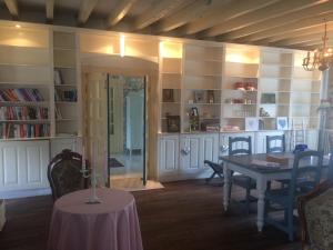 a dining room with a table and a book shelf at Chambres d'hotes La Chaumiere in Coulonges