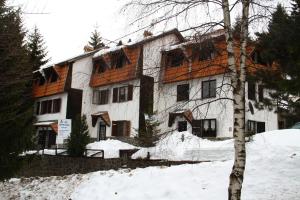 a large house with snow in front of it at AS Apartments in Kopaonik