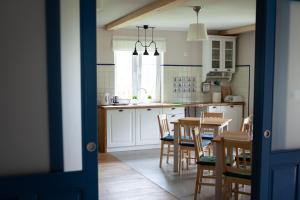 a kitchen and dining room with a table and chairs at Mazurska Gajówka in Ruciane-Nida