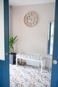 a clock on the wall above a bench in a room at Mazurska Gajówka in Ruciane-Nida
