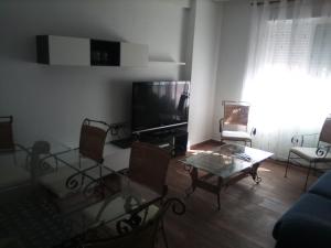 un soggiorno con TV, tavolo e sedie di Casa en el corazón de la Huerta murciana a Alquerías