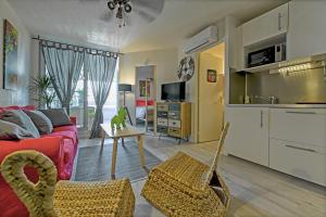 uma sala de estar com um sofá e uma mesa em T2 cosy de 41m2 à 400 m de la plage, résidence avec piscine. em Le Grau-du-Roi