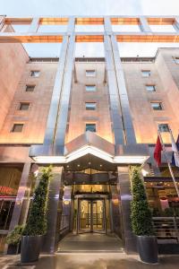 a hotel entrance with plants in front of a building at Zorlu Grand Hotel Trabzon in Trabzon