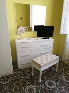 a bedroom with a dresser with a mirror and a stool at Appartamento cuore al centro di Taranto in Taranto