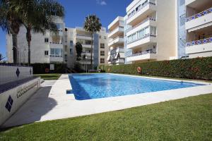 a swimming pool in front of a building at Andalhue Apartment in Marbella