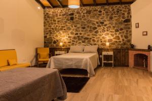 um quarto com uma cama e uma parede de pedra em Portantiqua, guest house em Góis