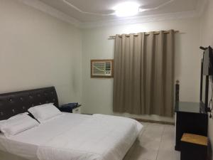 a bedroom with a bed and a shower curtain at Wahat Al Yarmouk Serviced Apartments in Ţubarjal +56 photos