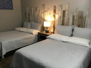 a hotel room with two beds and two lamps at Motel La Source in Coaticook