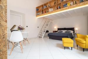 ナポリにあるEcce Homo 28のベッドルーム1室(ベッド1台、黄色い椅子付)