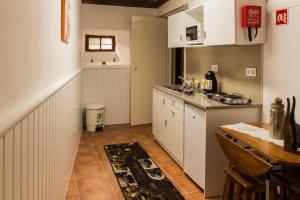 a small kitchen with white cabinets and a table at Portantiqua, guest house in Góis