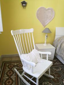 a white rocking chair in a bedroom with a bed at Appartamento cuore al centro di Taranto in Taranto