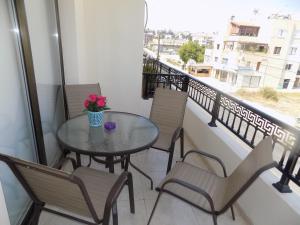 a table and chairs on a balcony with a window at Eva Luxury Apartment in Paphos