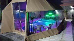 Tienda de campaña con piscina por la noche en Complejo Casas del Mirador, en Barra del Chuy