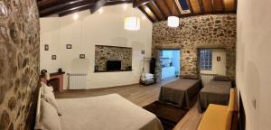 a large room with two beds and a fireplace at Portantiqua, guest house in Góis