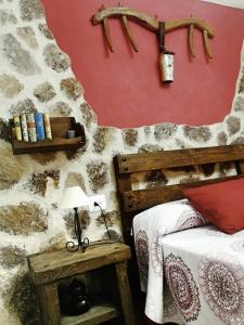 a bedroom with a bed and a red wall at Casa Rural La Presa in Valdeobispo