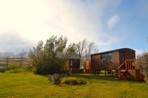 Quelques cabines dans un champ herbeux dans l'établissement Hostería Tercera Barranca, à Torres del Paine