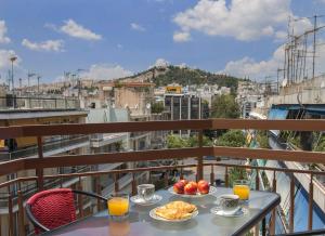 einen Tisch mit Tellern aus Essen auf einem Balkon in der Unterkunft Acropolis Gem by GHH in Athen