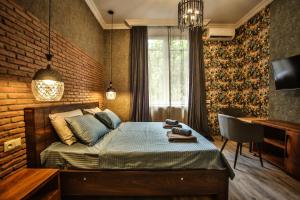 um quarto com uma cama, uma secretária e uma janela em Classy Apartments Central em Tbilisi