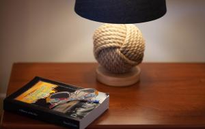 a table with a lamp and a book and glasses at Alphabet Fleet Inn in Twillingate