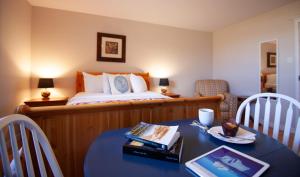 a bedroom with a bed and a table with a table sidx sidx sidx at Alphabet Fleet Inn in Twillingate