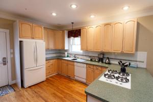 a kitchen with wooden cabinets and a white refrigerator at Lamp Post Lodge in Westcliffe