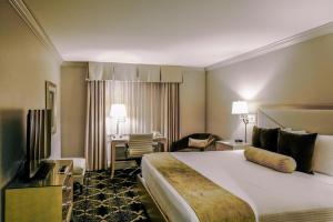 a hotel room with a large bed and a desk at Bell Tower Hotel in Ann Arbor