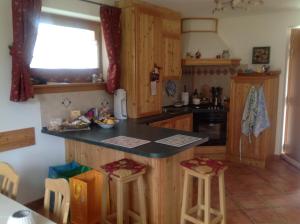 a kitchen with wooden cabinets and a counter with stools at Le Dimore Dei Begai in Massimeno