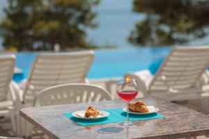 una mesa con una copa de vino tinto y cruasanes en Villa Charlotte, en Omiš