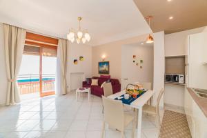 una cucina e un soggiorno con tavolo e divano di Belvedere Apartment ad Amalfi