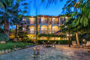 a building with a patio and a table in front of it at Calypso Studios in Amoudi