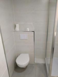 a white bathroom with a toilet and a mirror at Piles playa in La Playa de la Torre de Piles +5 photos
