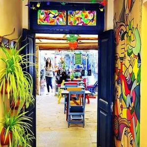 a door into a restaurant with a table and chairs at Giramundo Hostel in Humahuaca