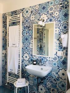 - une salle de bains bleue et blanche avec lavabo et miroir dans l'établissement Nereide, à Tropea
