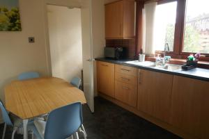 cocina con mesa de madera, mesa y sillas en Inverness Family House, en Inverness