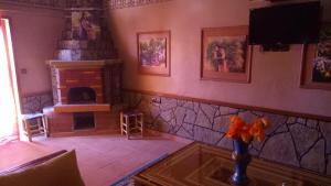 sala de estar con chimenea y TV en La Kasbah De Dades, en Boumalne